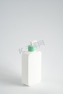 液体容器摄影照片_带泵分配器的大白色塑料瓶，作为凝胶、乳液、奶油、洗发水、沐浴泡沫的液体容器，白色背景。