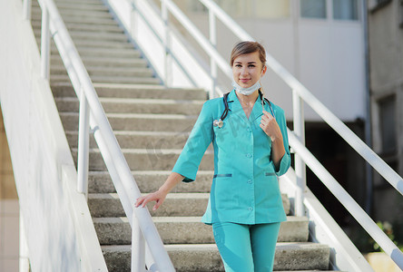 戴着防护面罩走上楼梯的女医生或护士