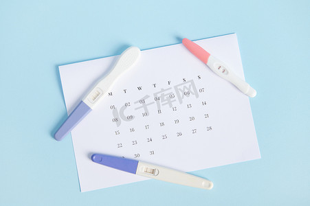 白色日历上的喷墨妊娠测试，标有末次月经的日期。
