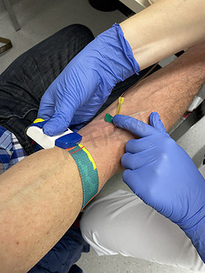 戴手套的护士摄影照片_戴蓝色手套的护士、医生或医疗技术人员采集血样