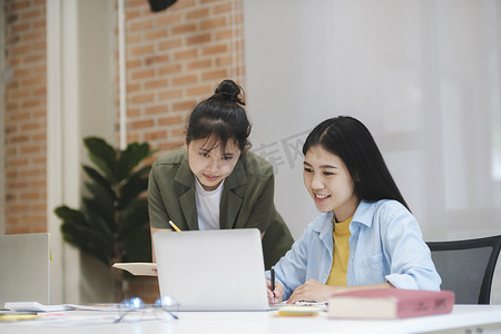 学术汇报摄影照片_学习学习的年轻亚洲大学生讨论在计算机上工作。