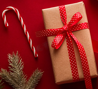 圣诞礼盒红色摄影照片_圣诞礼物、节礼日和传统节日礼物平躺，红色背景的经典圣诞礼盒，包装有节日装饰品和节日平躺装饰的礼物
