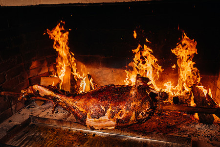 吐口水卡通摄影照片_羊肉完全在火上烤熟。