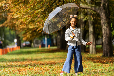 秋季公园雨中带伞行走的小孩