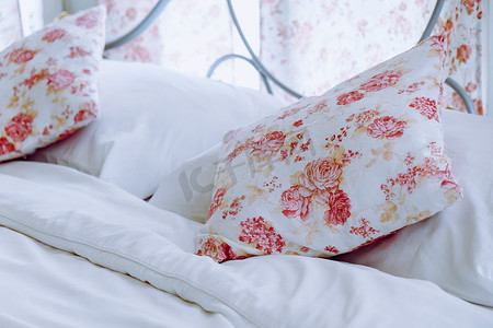明亮的卧室内饰，床上配有花卉图案枕头