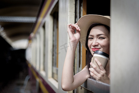 亚洲女旅客在火车上与 happi 一起喝咖啡