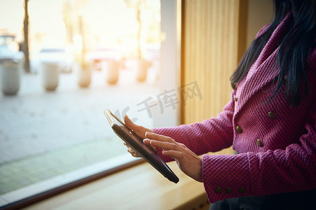 穿着时尚休闲装的裁剪视图女性使用数字平板电脑远程工作，为她的商业项目采取新行动