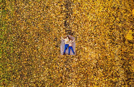 眼睛透视摄影照片_躺在黄叶上的姐妹