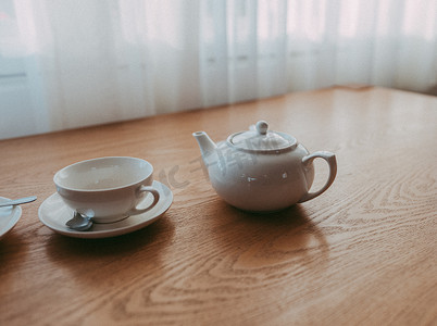 静物画与木制棕色桌子上的白色茶壶和茶杯