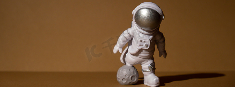 米色中性背景的塑料玩具人物宇航员复制空间。