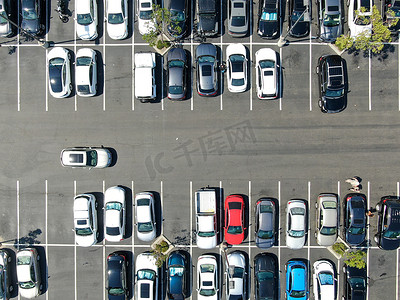 购物中心停车场的鸟瞰图，停有各种彩色车辆。