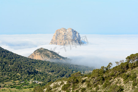 一个秋天的早晨，西班牙巴利阿里群岛伊维萨岛桑特霍塞普德萨塔莱亚的山峰是韦德拉透过雾气窥视
