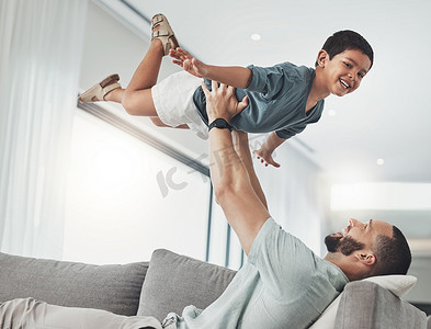 家人、爸爸和孩子在沙发上的空中享受假期、假期和周末在客厅玩耍。