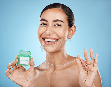 妇女、牙线和微笑在肖像中与牙科保健、清新口气和牙齿清洁隔离在蓝色背景。