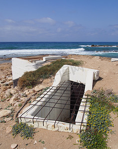塞浦路斯帕福斯海滩上一座废弃的旧混凝土军事掩体的入口
