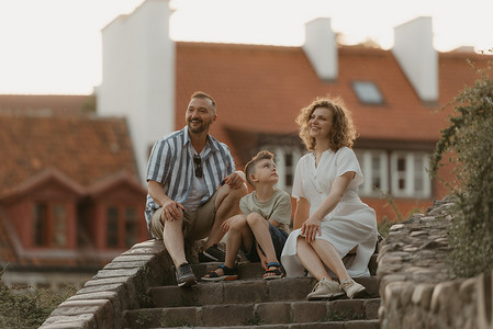 在一个古老的欧洲小镇的屋顶之间的楼梯上，一家人正在放松