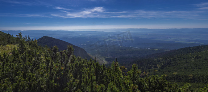 从塔特拉山小径上欣赏山谷的全景，远处有塔特兰斯卡洛姆尼采和蓝色薄雾笼罩的山坡。