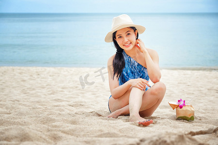 海滩上喝新鲜椰子水的快乐女人