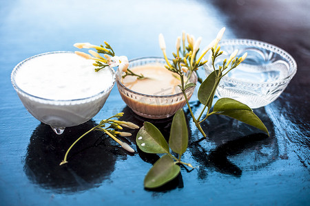 印度茉莉花的阿育吠陀面膜，装在木质表面的玻璃碗中，即茉莉花花瓣与牛奶奶油和水充分混合。