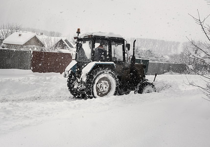 一辆小拖拉机清除道路上的积雪