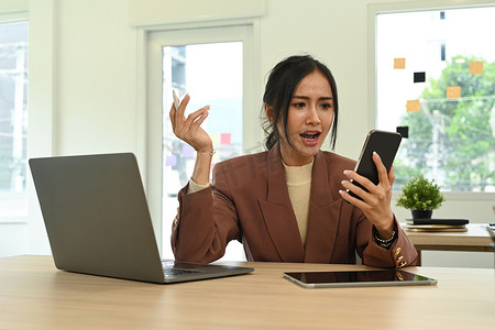 愤怒的女人盯着手机屏幕，对互联网连接速度或低信号设备问题感到恼火