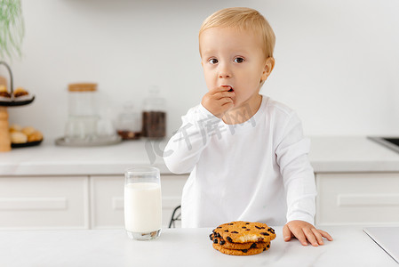 男孩早上喝牛奶和饼干。