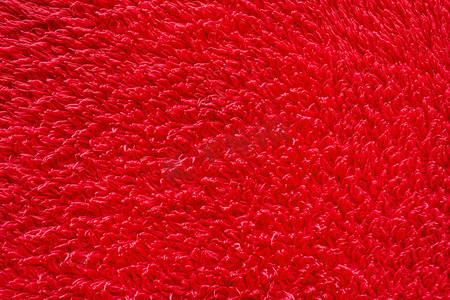 红色的地毯摄影照片_红色毛皮背景，柔软的羊毛材质