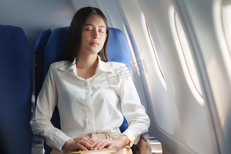 豪华飞机摄影照片_美丽的亚洲女商人睡在豪华航班上。