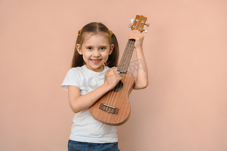 白种人微笑快乐小学年龄女孩学习音乐弹吉他