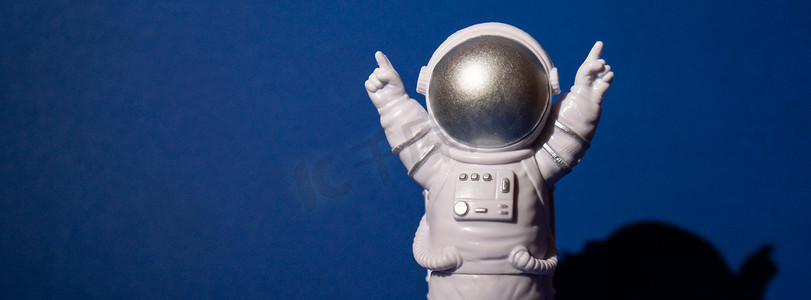 地球航行摄影照片_彩色蓝色背景的塑料玩具宇航员复制空间。