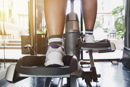 女人在健身房的机器上锻炼。健身的概念。