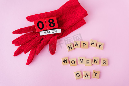 美丽的红色蕾丝手套，上面的木立方体上刻有 3 月 8 日的铭文，妇女节快乐的铭文。