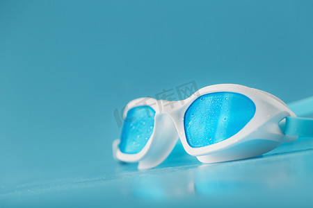 蓝色背景白色框架中的游泳镜