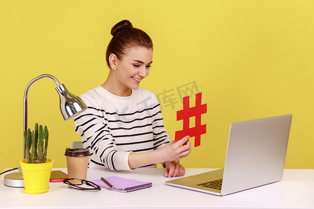 坐在工作场所的女性，在笔记本电脑屏幕上显示大红色标签符号，分享病毒内容。