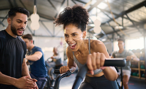 健身房、健身和骑自行车的女性与私人教练一起进行激励、支持和力量锻炼、欢呼和拍手。