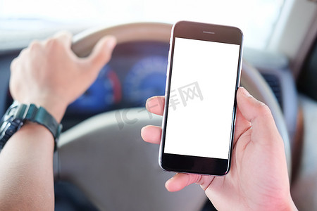 司机摄影照片_裁剪镜头视图 驾驶员在开车时使用手机。