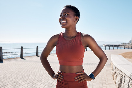 黑人女跑步者，微笑着，在海边长廊上快乐，以实现健康、健身和夏季身体目标。
