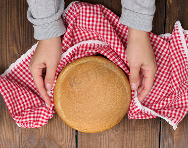 木板上的圆形烤面包，棕色的桌子。