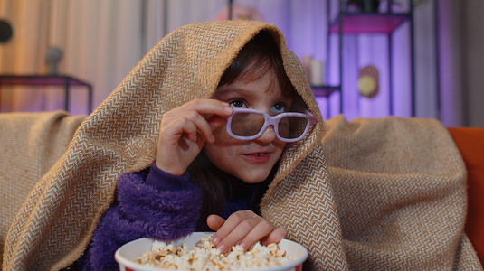 Oreteen 女孩在家里的沙发上吃爆米花，看有趣的电视剧，体育游戏在线内容