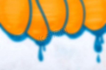 白色混凝土墙纹理上橙色和蓝色涂鸦的模糊背景