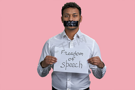 封箱胶带标签摄影照片_印度男子的嘴被胶带封住，并有言论自由铭文。