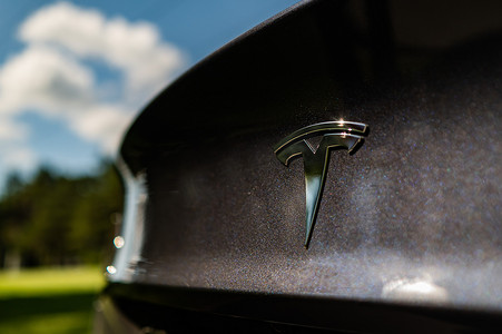 金属的符号摄影照片_俄罗斯新西伯利亚 - 2022年8月10日：黑色汽车上特斯拉标志的特写。