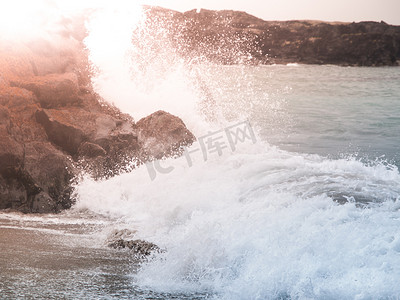 水泡沫水花摄影照片_碎波在岩石海岸上溅起的水花