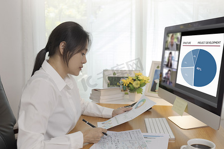 工作总结墨绿色摄影照片_在家工作的亚洲女商人通过视频进行在线会议