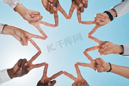 团队建设、蓝天或带有和平标志的手，以支持、团队合作或伙伴合作。