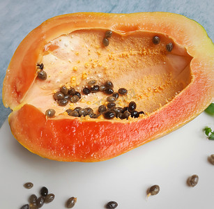 橙色新鲜木瓜切成两半，保持白色背景，富含纤维维生素 C 和抗氧化剂增强免疫力对糖尿病患者和眼睛有益