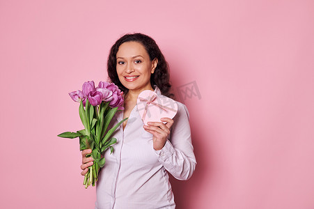美丽的孕妇拿着紫色郁金香花束和心形礼盒，上面有母亲节快乐的礼物