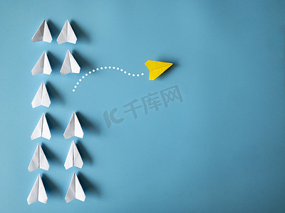 黄纸飞机折纸将其他白色飞机留在蓝色背景上，并带有可定制的文本空间。