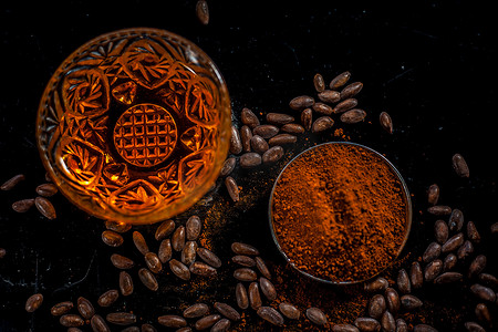 黑色木质表面上的抗衰老咖啡面膜，由一些咖啡豆和蜂蜜组成。