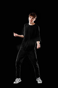 穿着黑色T恤和牛仔裤跳舞的年轻人